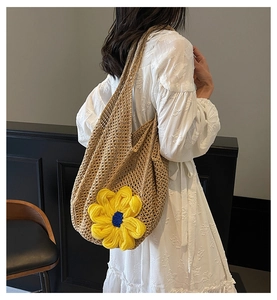 Detailed close-up of a hand-woven hollow-out tote bag with a large yellow floral motif