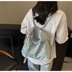 Détail du sac fourre-tout bleu clair verni avec petit porte-monnaie et bretelles