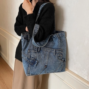 Vintage blue washed denim tote bag with retro jeans pocket details and long shoulder straps