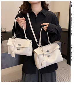 Detail of cream tote bags in two sizes with silver metal clasps and thin straps