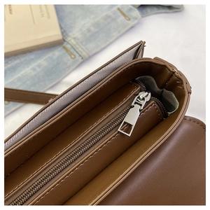 Detail view of the brown shoulder bag interior with silver zipper and smooth lining