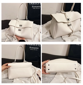 Detail view of cream tote bag with pebble leather texture, silver twist lock and base studs