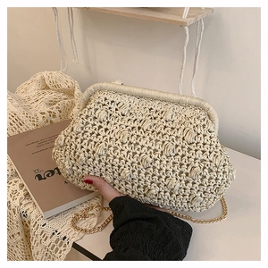 Detailed view of the beige woven cloud bag with gold metal chain and retro clasp