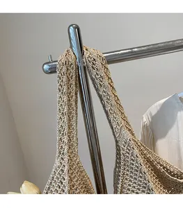 Detail of reinforced woven shoulder strap on the beige straw tote bag for durability
