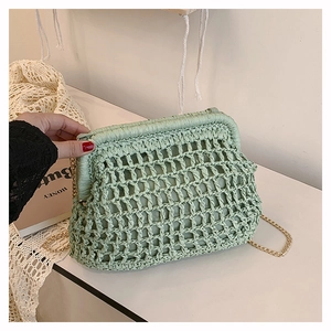 Detailed view of a mint green hand-woven clutch bag featuring a metal clasp and chain