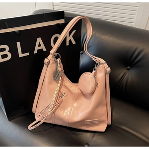 Détail d'un cabas rose brillant avec petit porte-monnaie rond et breloque tressée