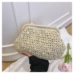 Detail of hand-woven cream clutch bag with gold chain strap and vintage metal clasp