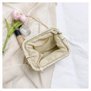 Detail view of the woven clutch interior with chain strap and lining storage