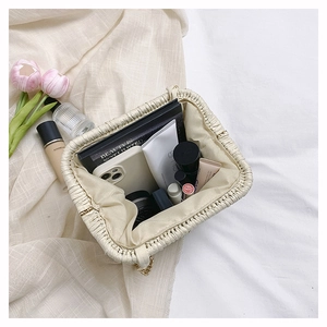 Interior view of beige woven clutch showing large capacity for phone and cosmetics