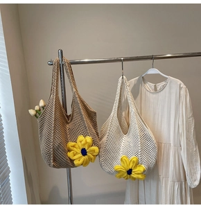 Detail of hand-woven hollow tote bags with large yellow knit flower accents in two colors