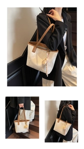 Detail of off-white tote bag with marble texture and cute plush bear keychain