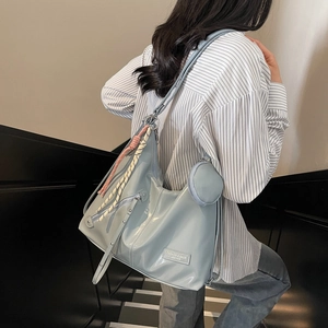 Sac fourre-tout bleu clair en similicuir avec breloque tressée en milieu urbain