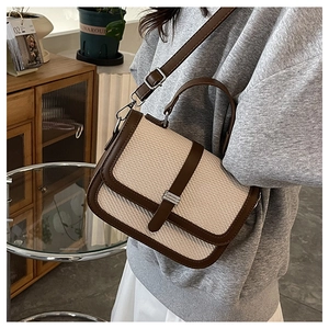 Detail of a color-block crossbody bag with beige woven fabric and dark brown leather trim