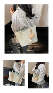 Detail of light green tote bag featuring striped scarf, bear charm and shoulder straps