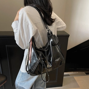 Sac fourre-tout en cuir noir avec pochette, porté par un mannequin dans un décor épuré