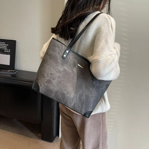 Minimalist large grey tote bag for women with gold hardware shown from a side profile