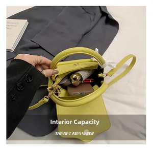 Internal capacity of lime green crossbody bag with daily essentials inside the compartment