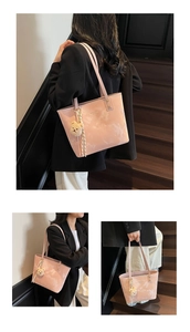 Pink tote bag detail with marble texture, logo print and brown plush bear charm