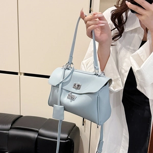 Minimalist light blue tote bag with silver rotary lock and adjustable crossbody strap