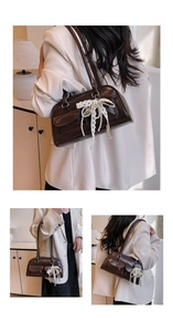 Détails d'un sac bowling vintage en cuir marron avec dentelle et breloque perle