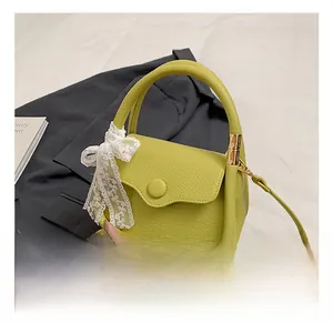 Detailed shot of lime green pebbled leather mini tote with elegant lace bow decoration