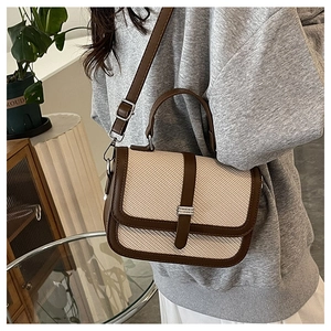 Detail view of woven leather patchwork shoulder bag showing texture and silver hardware