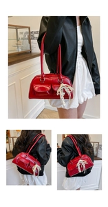 Détail du sac bowling en cuir rouge brillant avec poches aimantées et nœud en dentelle