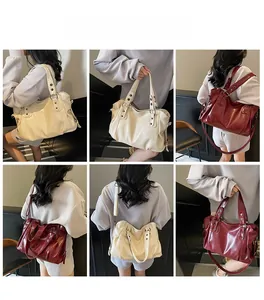 Detail view of large tote bag with metal studs, adjustable strap in cream and wine red
