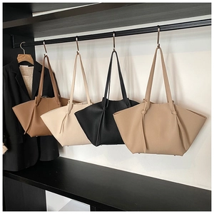 Detailed close-up of tote bags in four colors with pebbled texture and wing design