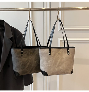 Detail of minimalist tote bags featuring marble texture and metallic logo plaque detail