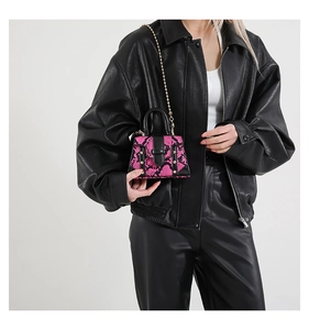 Chic pink and black snake pattern mini handbag styled with a black leather jacket