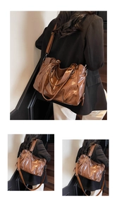 Detail of vintage brown tote bag showing smooth leather texture and bronze hardware
