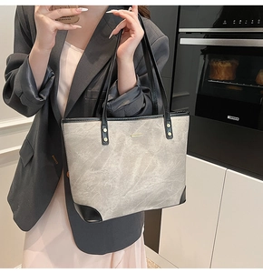 Detail of trendy marble pattern tote bag featuring black contrast trim and gold accents
