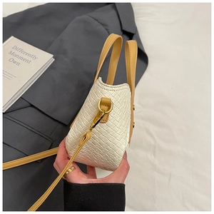 Détail du sac à main tissé blanc avec bandoulière en cuir jaune et accessoires dorés
