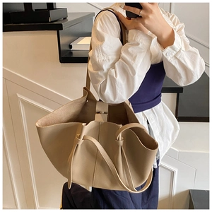 Close-up of beige lychee texture leather tote bag with elegant wing-style folding design