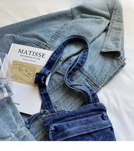 Dettaglio della tracolla regolabile e della fibbia della borsa tote in denim blu scuro