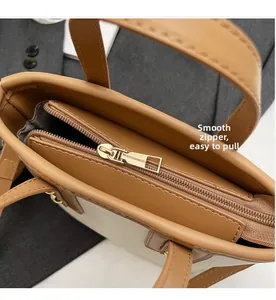 Detailed top view of the smooth golden metal double zipper on the contrast bucket bag