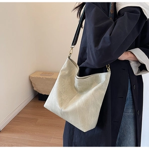 Detail of vintage beige tote bag with retro printed wide strap and gold hardware accents