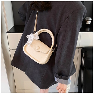 Detailed shot of cream PU leather tote bag with lace bow handle and refined texture