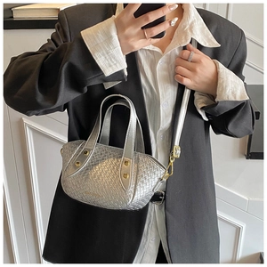 Détail du sac seau argenté tressé avec gaufrage en treillis et finitions dorées chic