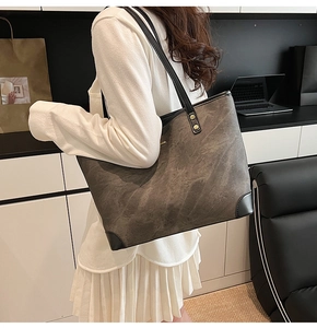 Detail of trendy marble texture tote bag with leather piping and gold rivet accents