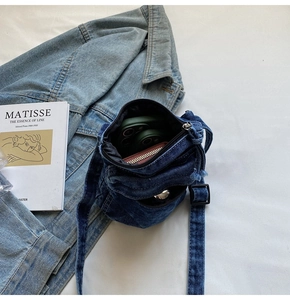 Dettaglio della piccola borsa a tracolla in denim blu con tracolla regolabile e lavaggio vintage
