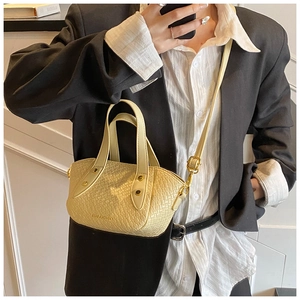 Petit sac fourre-tout tressé jaune clair sur mannequin en blazer noir pour le style
