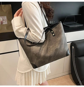Detail of vintage tote bag featuring smoked grey texture and black leather rivet straps