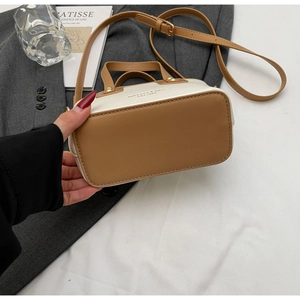 Detail of the brown and beige patchwork handbag with adjustable shoulder strap and hardware