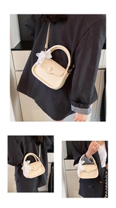 Close-up of cream PU leather tote bag featuring litchi texture and lace bow detail