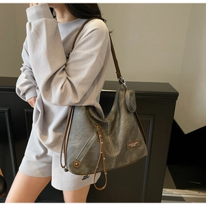 Detail of grey large capacity tote bag with brown leather straps and small coin pouch