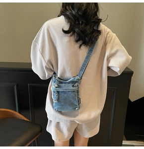 Vista posteriore di una modella con borsa a tracolla compatta in denim blu lavato