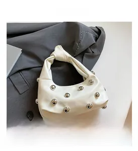 Detail of off-white faux leather hobo bag with silver rivets and unique knot handle