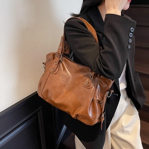 Vintage brown PU leather oversized tote bag with adjustable straps on female model